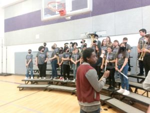 The percussionist looks on as the Concert Band arranges themselves on the bleachers.