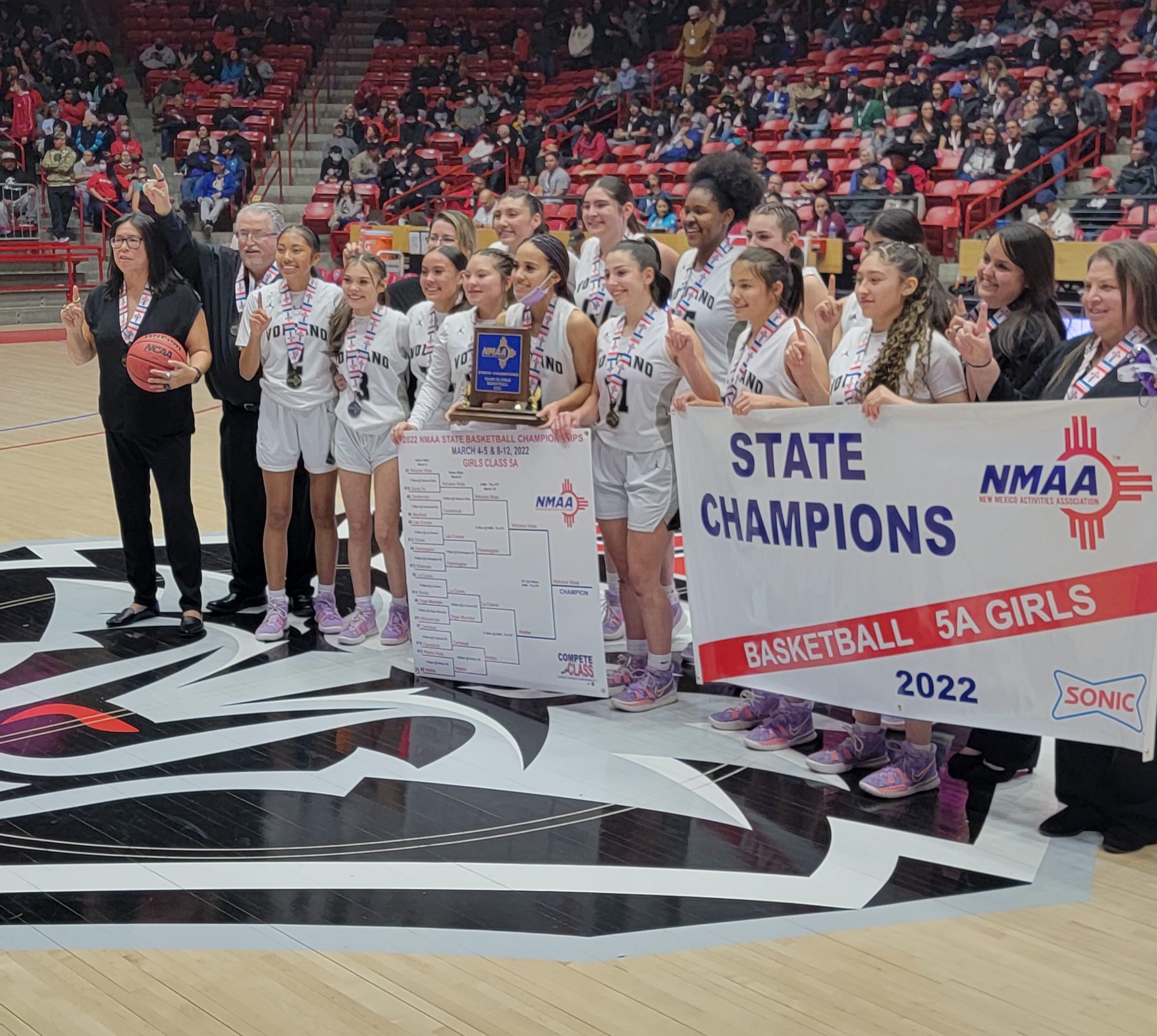 Volcano Vista players pose with their championship banner after beating Hobbs in the 5A title game Friday.