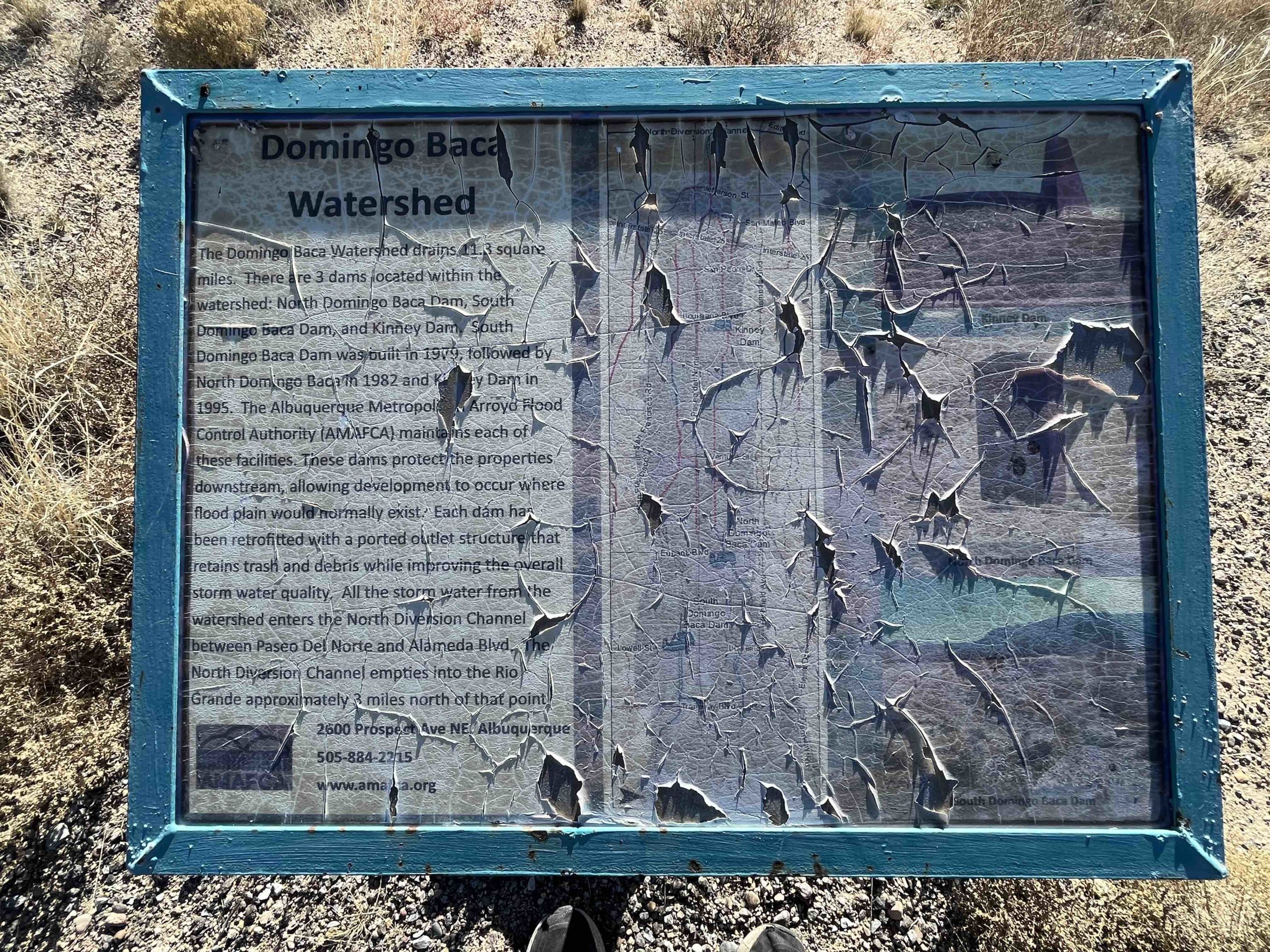 A tattered sign provides information on the North Domingo Baca Watershed. (Scott Albright/Neighborhood Journal)